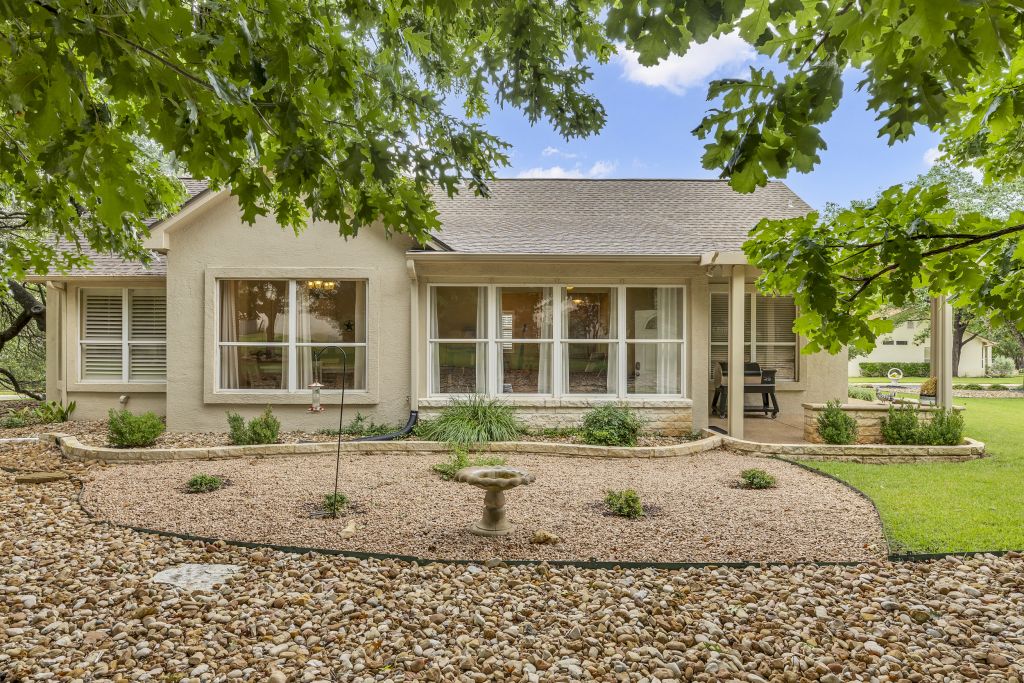 144 Cattle Trail Way Georgetown, TX 78633 - Photo 26 of 37 A well-maintained rock garden and covered patio provide a serene outdoor living space.