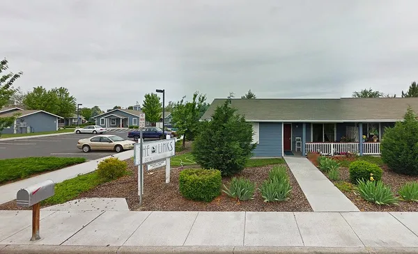 a front view of a house with a yard and potted plants