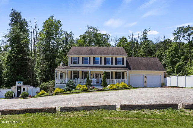 a view of a house with a big yard and potted plants