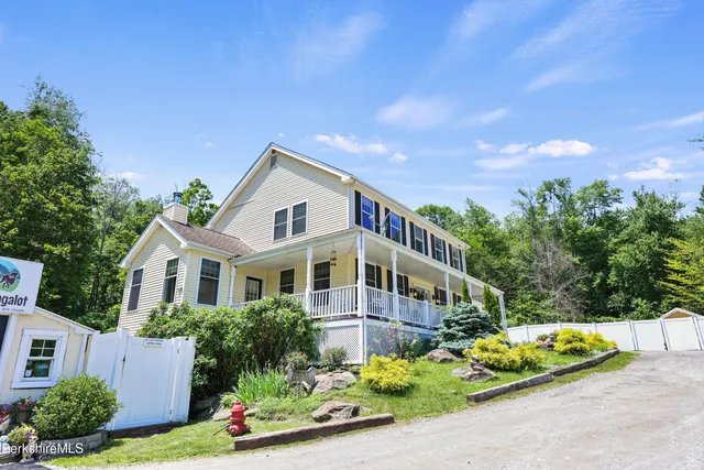 a view of a house with a yard and potted plants