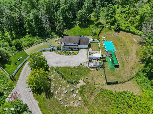 an aerial view of a house with garden space pool seating area and yard