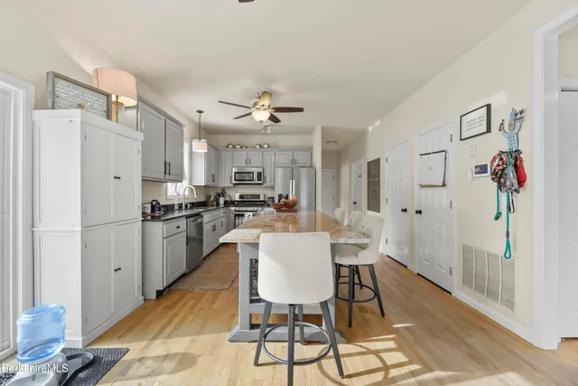 a view of kitchen with refrigerator and wooden floor