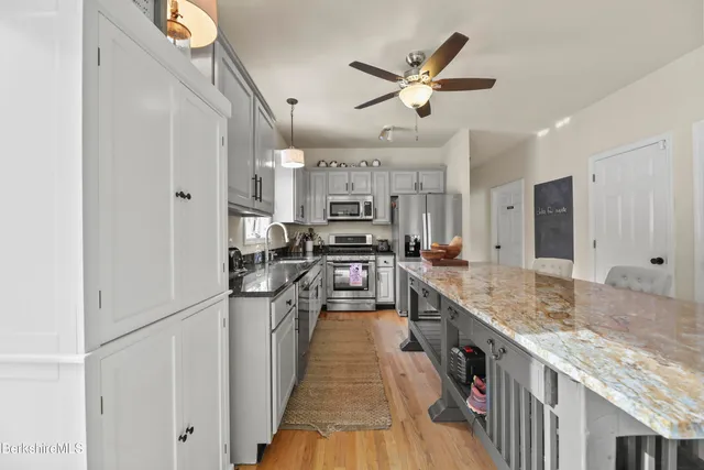 a kitchen with stainless steel appliances granite countertop lots of counter top space and wooden floor