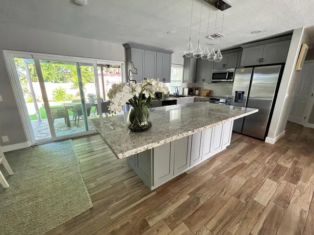 a kitchen with stainless steel appliances granite countertop a sink stove and wooden floor