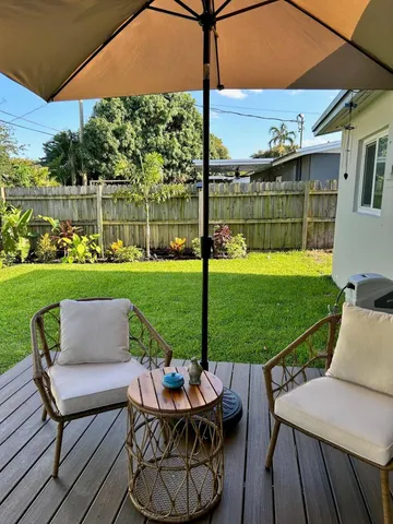 a view of a patio with table and chairs under an umbrella