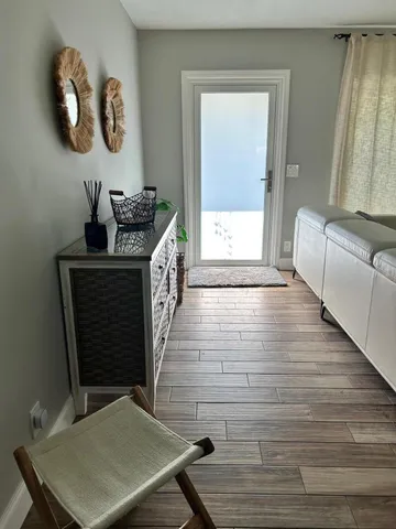 a view of a hallway to a livingroom with furniture