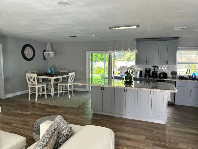 a kitchen with granite countertop a dining table chairs and a large window