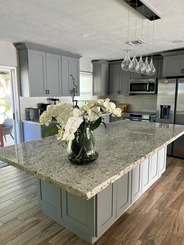 a kitchen with stainless steel appliances granite countertop a sink counter space and wooden floor