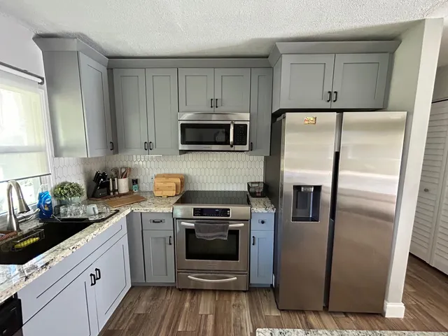 a kitchen with a refrigerator sink and stove top oven