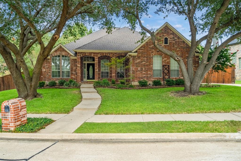 4405 Ridgecove Drive Rowlett, TX 75088 - Photo 1 of 37 Brick exterior, arched windows, gabled roofline, concrete walkway, and manicured lawn