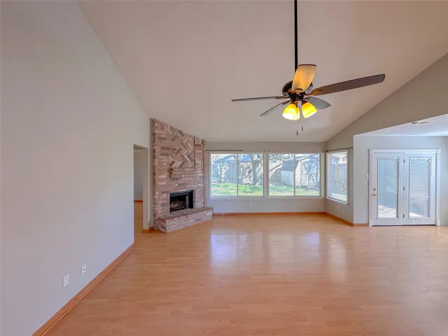 an empty room with a fireplace and windows