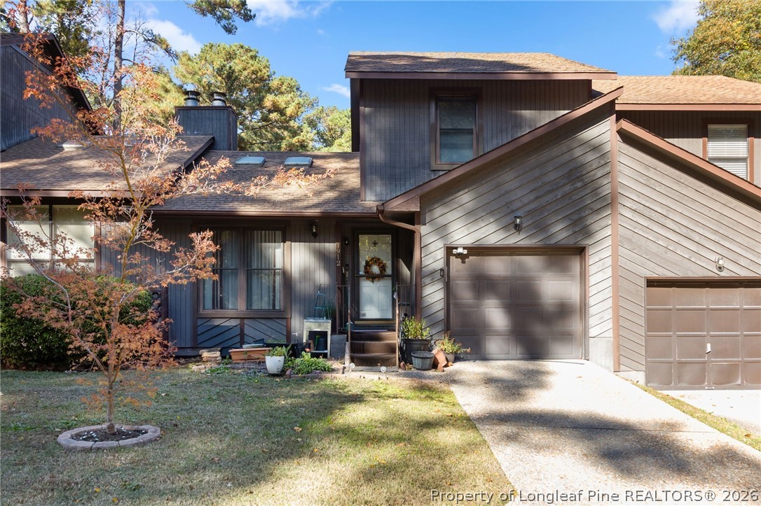 a view of a house with yard and garage