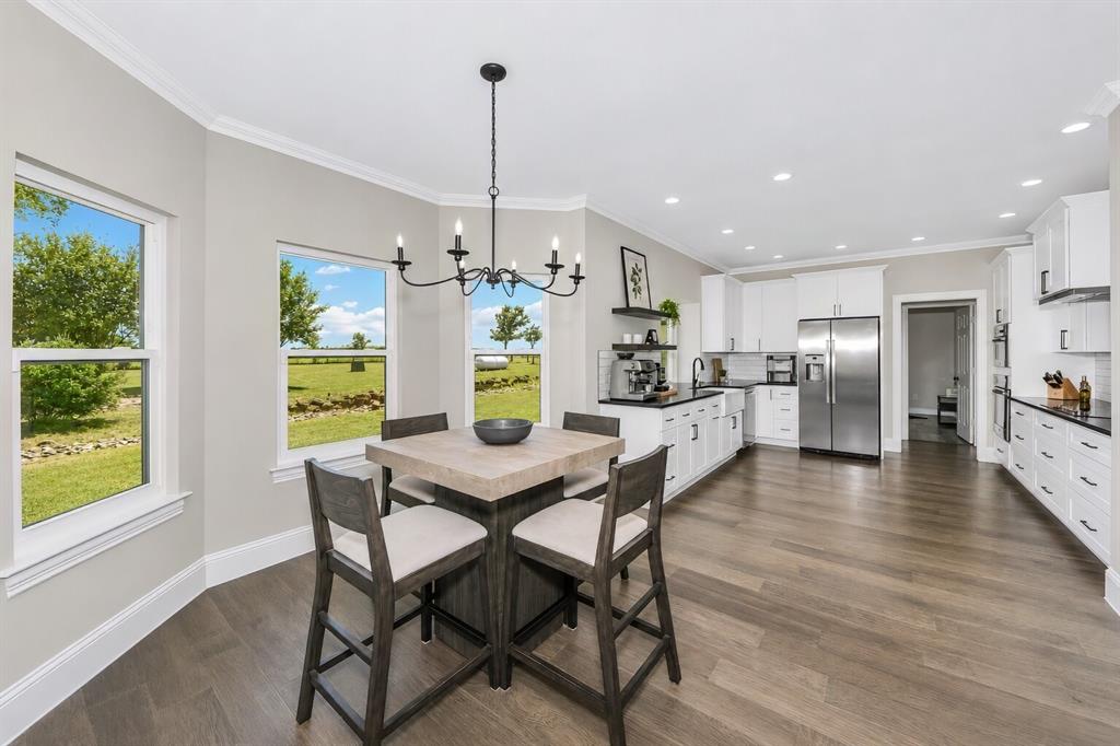 3817 Ganzer Road West Denton, TX 76207 - Photo 15 of 40 The breakfast nook sits right between the kitchen and living room, surrounded by windows that open to breathtaking views of the backyard and the landscape beyond. It’s a bright, easy spot for morning coffee, casual meals, or simply taking in the scenery. The layout keeps the space connected to the heart of the home while still feeling calm and tucked away.