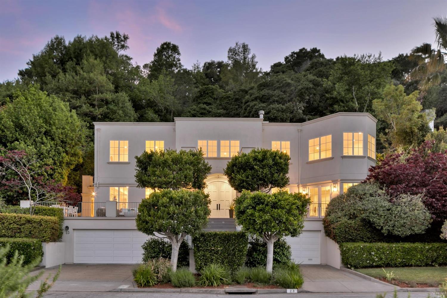 a front view of a house with a yard and tree s