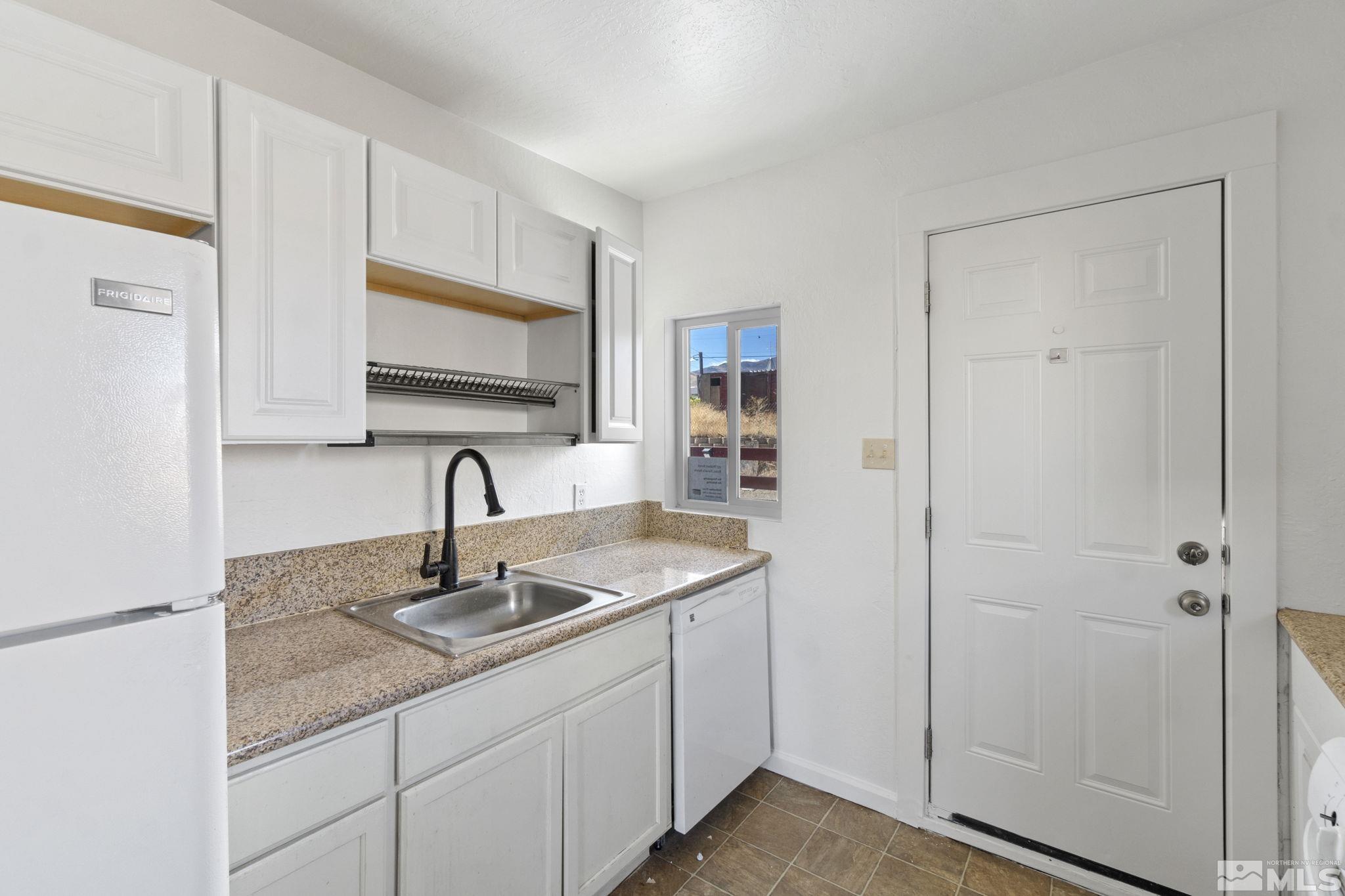 157 Walner Street Reno, NV 89506 - Photo 12 of 21 a kitchen with stainless steel appliances granite countertop a sink and a white cabinets