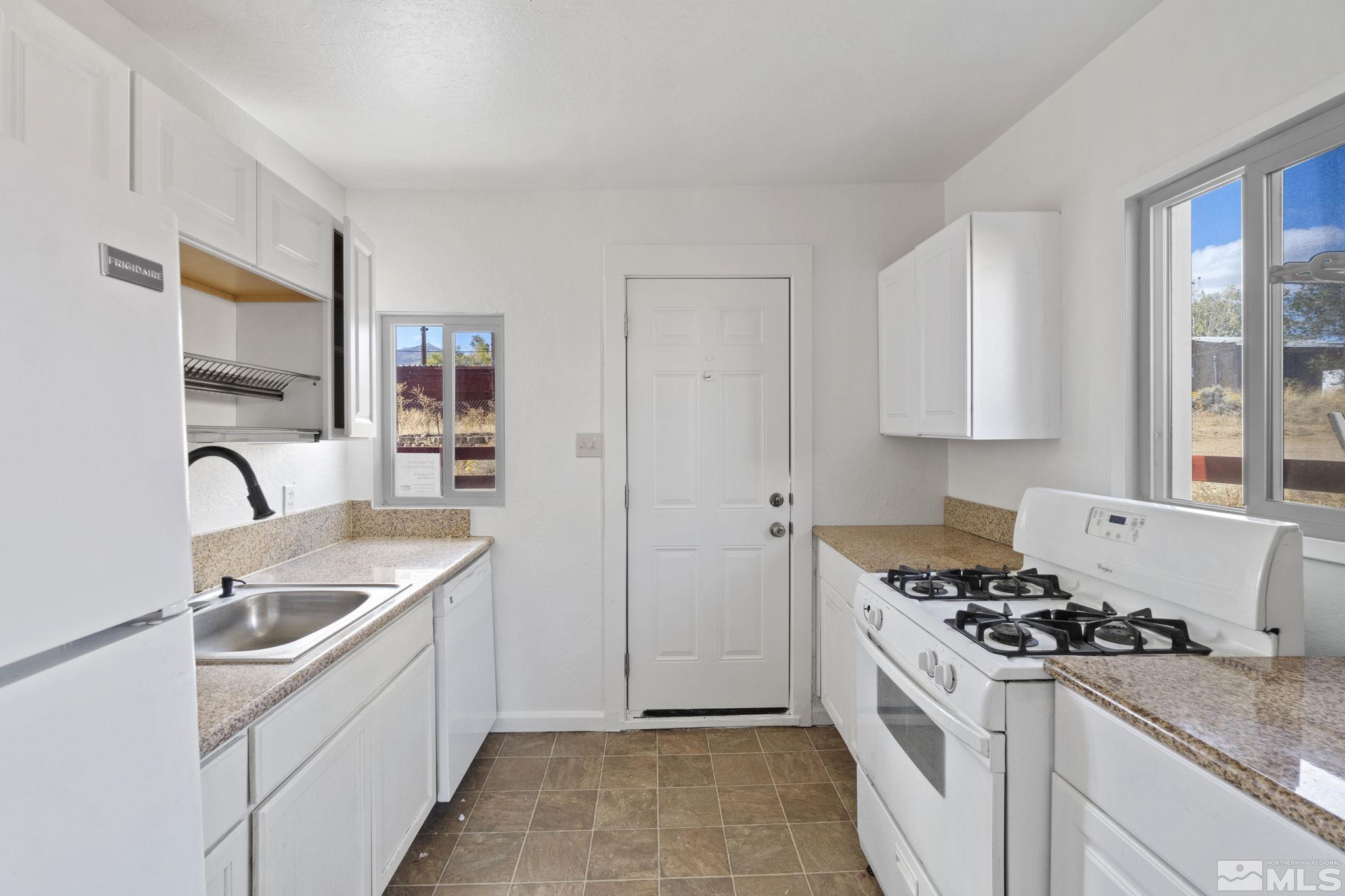 157 Walner Street Reno, NV 89506 - Photo 9 of 21 a kitchen with stainless steel appliances granite countertop a sink stove and refrigerator