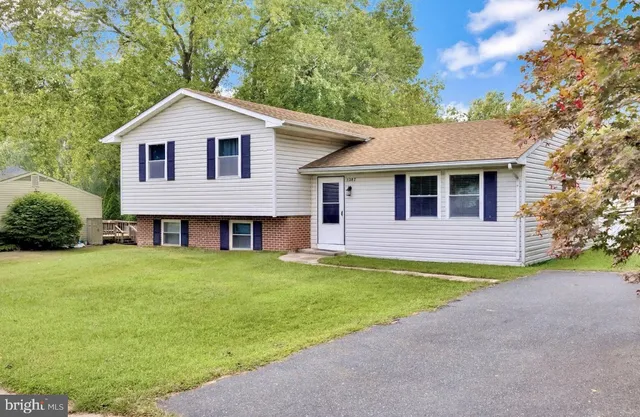a front view of a house with a garden and yard