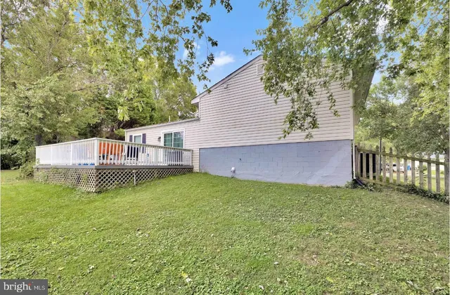 a view of a house with a yard and a large tree