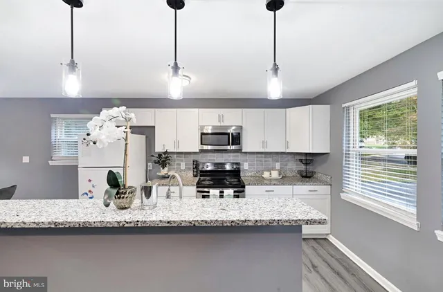 a kitchen with stainless steel appliances granite countertop a sink a microwave and cabinets