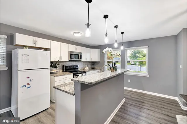 a kitchen with kitchen island white cabinets and white appliances