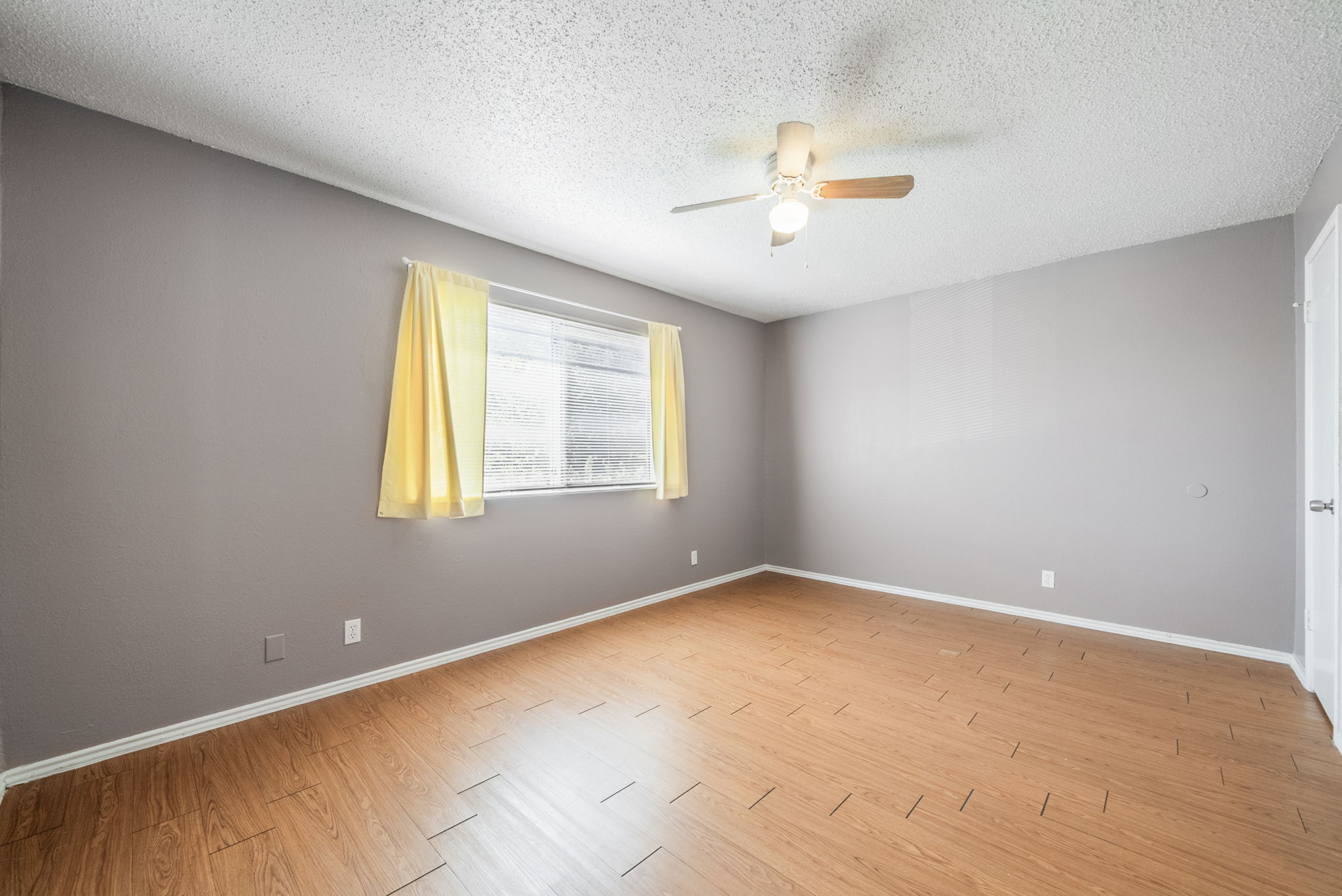 5807 Spring Meadow Road, Unit B Austin, TX 78744 - Photo 17 of 31 A well-lit bedroom with modern flooring and a practical ceiling fan.