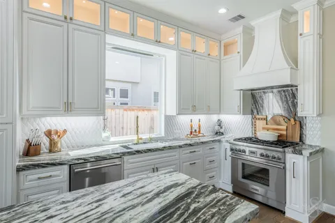 a kitchen with granite countertop a sink stainless steel appliances and cabinets