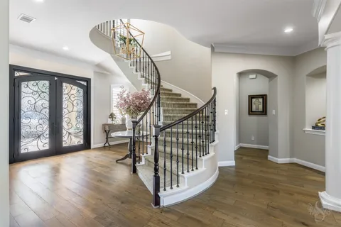a view of a hallway with wooden floor and stairs
