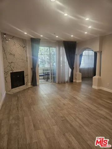 a view of empty room with wooden floor and fireplace