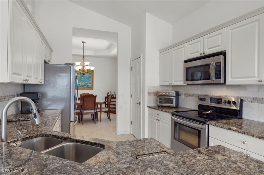 16253 Coco Hammock Way, Unit 201 Fort Myers, FL 33908 - Photo 1 of 34 a kitchen with sink a microwave and cabinets