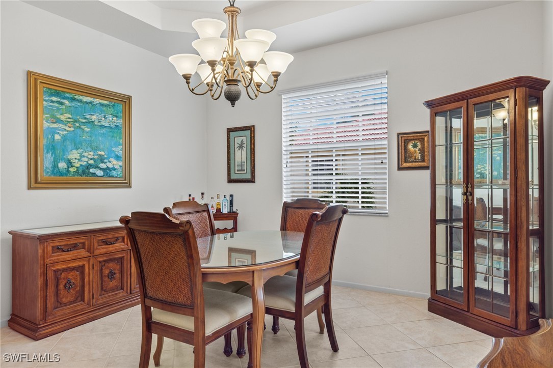 16253 Coco Hammock Way, Unit 201 Fort Myers, FL 33908 - Photo 13 of 34 a view of a dining room with furniture wooden floor and a chandelier