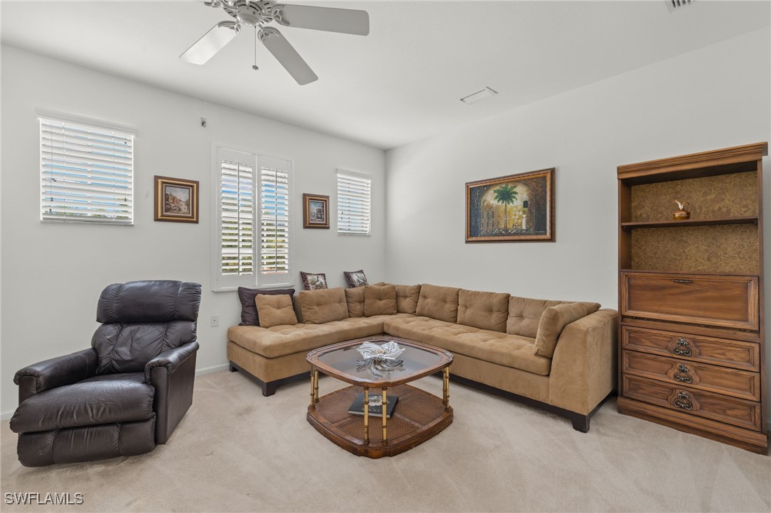 16253 Coco Hammock Way, Unit 201 Fort Myers, FL 33908 - Photo 14 of 34 a living room with furniture ceiling fan and a wooden floor