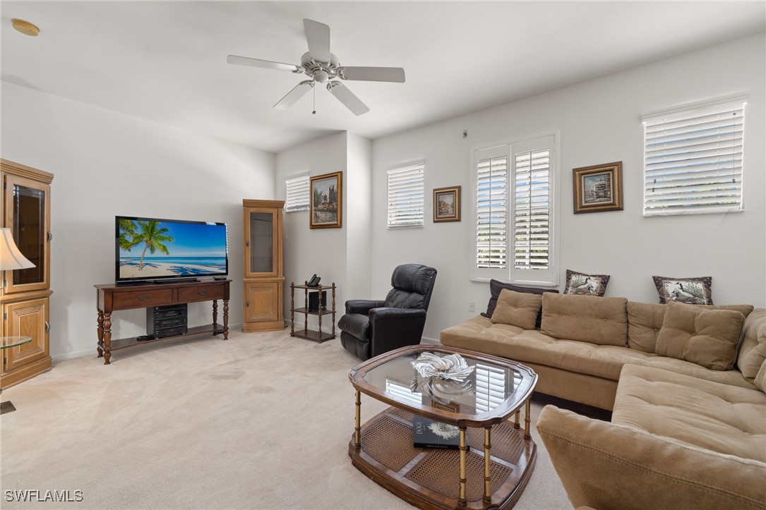 16253 Coco Hammock Way, Unit 201 Fort Myers, FL 33908 - Photo 16 of 34 a living room with furniture a fireplace and a flat screen tv