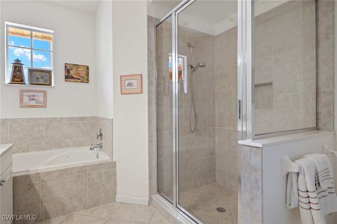 16253 Coco Hammock Way, Unit 201 Fort Myers, FL 33908 - Photo 24 of 34 a bathroom with a bathtub and shower