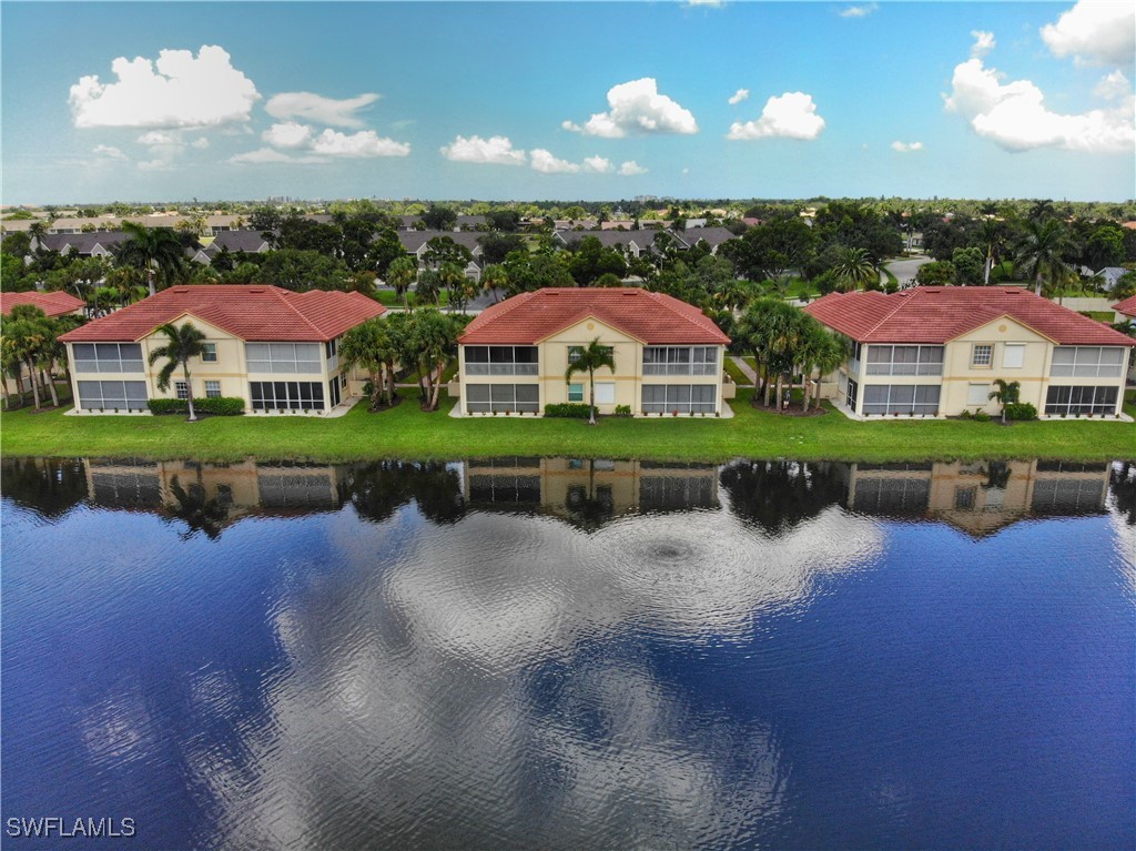 16253 Coco Hammock Way, Unit 201 Fort Myers, FL 33908 - Photo 29 of 34 a view of a house with a yard and a pond