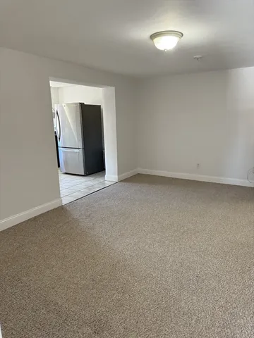 a view of an empty room with closet and bathroom