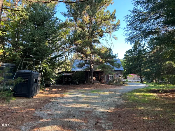 a view of a house with large tree and a yard