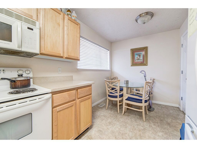 865 North 500 West, Unit 5 Provo, UT 84604 - Photo 2 of 14 Compact kitchen space featuring light wood cabinetry, white appliances, and a window with horizontal blinds
