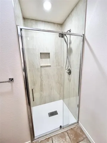 a bathroom with a glass door shower and a sink