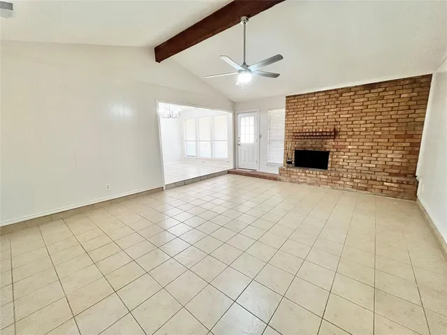 an empty room with windows and ceiling fan