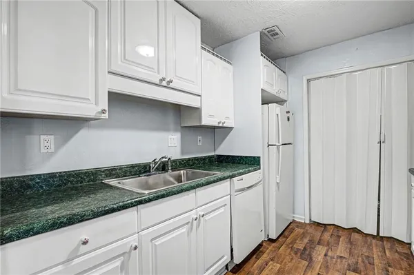 a kitchen with granite countertop a sink and cabinets