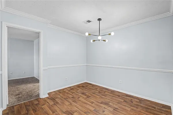 a view of a room with wooden floor and white walls