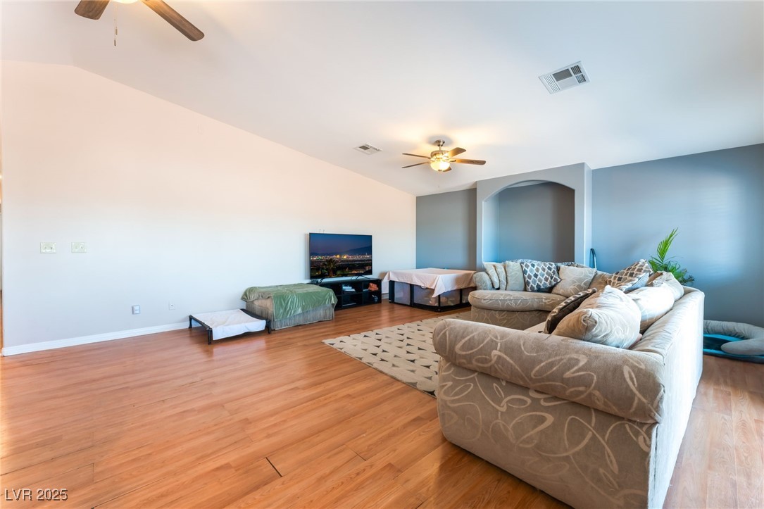 4656 East Desert Inn Road Las Vegas, NV 89121 - Photo 5 of 98 4656 E DI Living area with a ceiling fan, vaulted ceiling, and light wood-type flooring