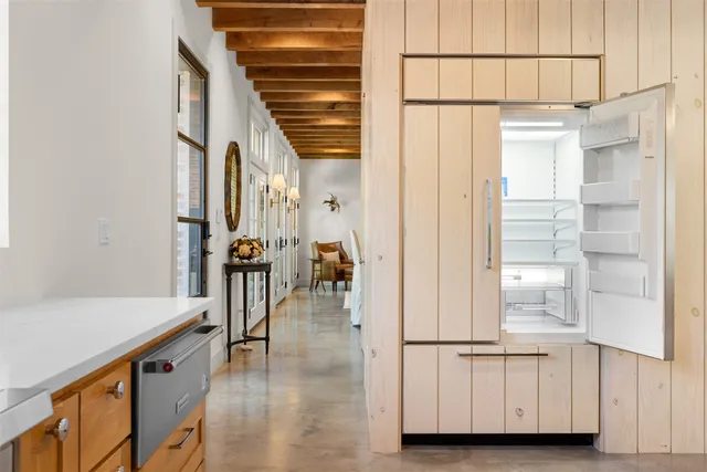 a hallway with white cabinets and wooden floor