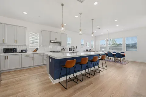 a kitchen with stainless steel appliances granite countertop a table chairs sink refrigerator and cabinets