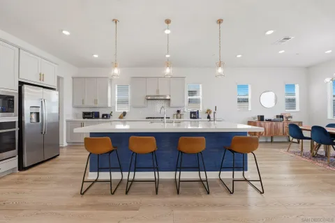 a kitchen with stainless steel appliances kitchen island granite countertop a sink and a refrigerator