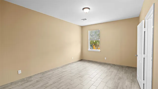 wooden floor in an empty room with a window