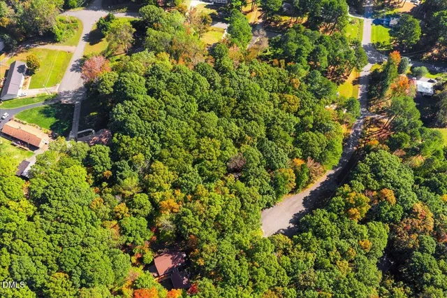 an aerial view of residential house with outdoor space and trees all around