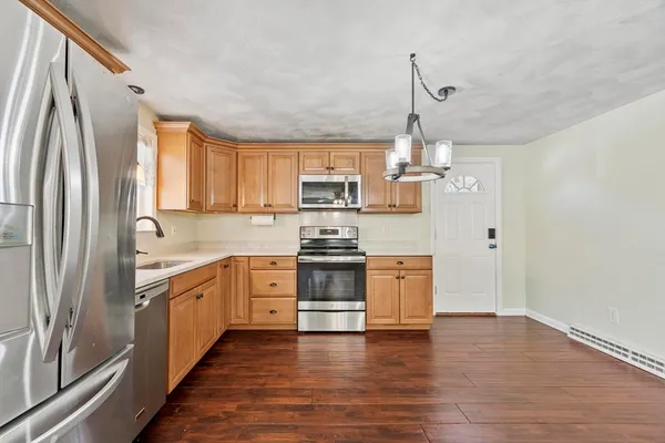 a kitchen with stainless steel appliances granite countertop a refrigerator a stove top oven a sink and dishwasher