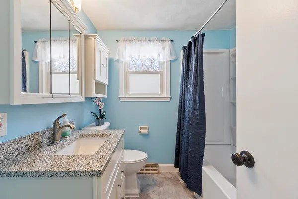 a bathroom with a granite countertop sink toilet and shower