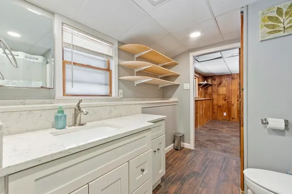 a bathroom with a sink a toilet and shower